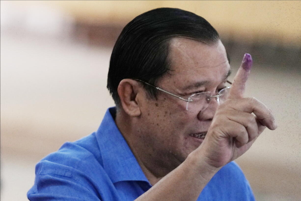 Cambodian Prime Minister Hun Sen shows off his inked finger at a polling station in Takhmua, in Kandal province, southeast of Phnom Penh, Cambodia, Sunday, June 5, 2022. Cambodians headed to the polls Sunday in local elections that are their first chance to vote since the ruling party of long-serving Prime Minister Hun Sen swept a 2018 general election that was widely criticized as unfair.
