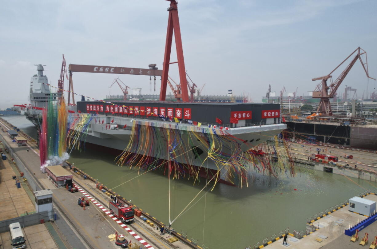 In this photo released by Xinhua News Agency, coloured smoke mark the launch ceremony for China's third aircraft carrier christened Fujian at a dry dock in Shanghai on Friday, June 17, 2022. China on Friday launched its third aircraft carrier, the first such ship to be both designed and built entirely within the country.