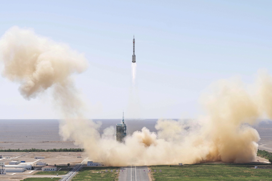 In this photo released by Xinhua News Agency, the Long March-2F carrier rocket carrying China's Shenzhou 14 spacecraft blasts off from the launch pad at the Jiuquan Satellite Launch Center in Jiuquan, northwest China's Gansu Province, Sunday, June 5, 2022. China on Sunday launched the new three-person mission to complete work on its permanent orbiting space station.