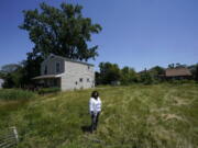 Donele Wilkins, founder of Green Door Initiative, a group that does environmental workforce development, stands in the field next to her childhood home where her company is developing a solar community hub, Tuesday, June 28, 2022, in Detroit. Fourteen smaller environmental justice organizations from around the United States, including Green Door Initiative, have begun to receive money under the Justice40 initiative to improve the environment in disadvantaged communities and help them prepare for climate change.