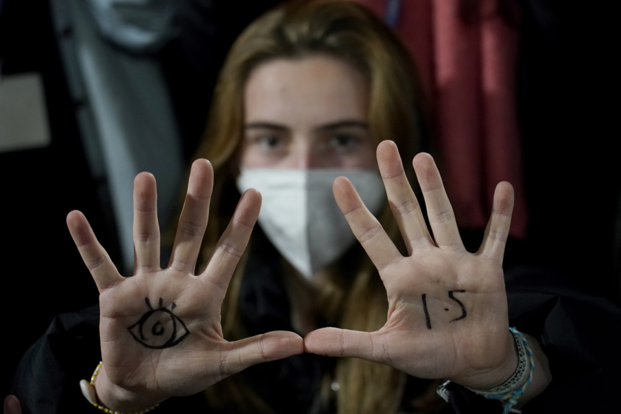 FILE - A youngster, with an eye drawn on her hand to show she is watching and 1.5 for countries to keep warming below 1.5 degrees Celsius, takes part in a Fridays for Future climate protest inside a plenary corridor at the SEC (Scottish Event Campus) venue for the COP26 U.N. Climate Summit, in Glasgow, Scotland, Nov. 10, 2021. The idea of tinkering with the air to cool Earth's ever-warming climate seems to be gaining momentum. Two new high-powered panels have started to look at the ethics and governing rules surrounding the controversial technologies of geoengineering.