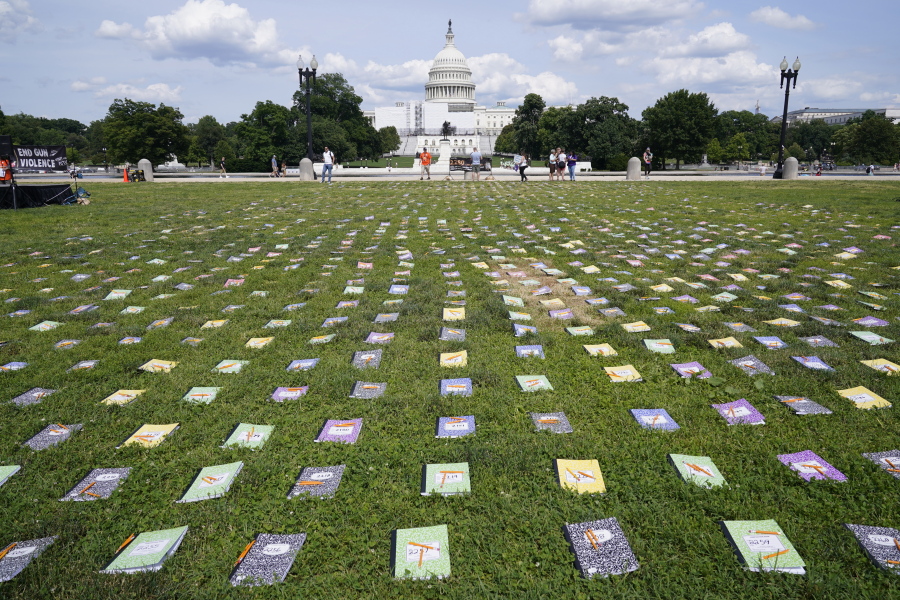 Laid out near the U.S. Capitol are 2,280 schoolbooks and broken pencils that represent the 2,280 children that have been killed by gun violence since the Senate has refused to bring a vote on background checks, during a rally in Washington, Friday, June 10, 2022.