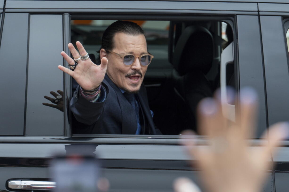 Actor Johnny Depp waves to supporters as he departs the Fairfax County Courthouse Friday, May 27, 2022 in Fairfax, Va.  A jury heard closing arguments in Johnny Depp's high-profile libel lawsuit against ex-wife Amber Heard.