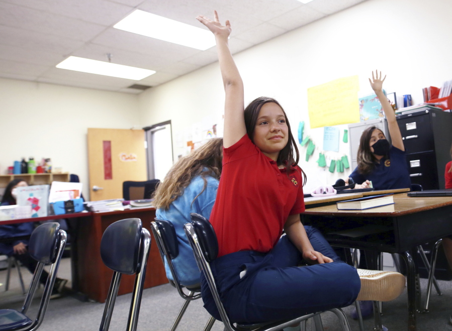 Lilianna Naizer-Baldwin, 10, foreground center, raises her hand during her Spanish class at the New Mexico International School on May 27 in Albuquerque, N.M.  New Mexico is the only state in the country where the right to learn in Spanish is laid out the constitution.