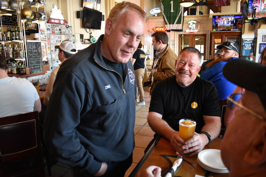 FILE - Montana U.S. House candidate and former Secretary of Interior Ryan Zinke, left, speaks with patrons at Metals Sports Bar and Grill, May 13, 2022, in Butte, Mont. Zinke is seeking election to a newly created U.S. House district.