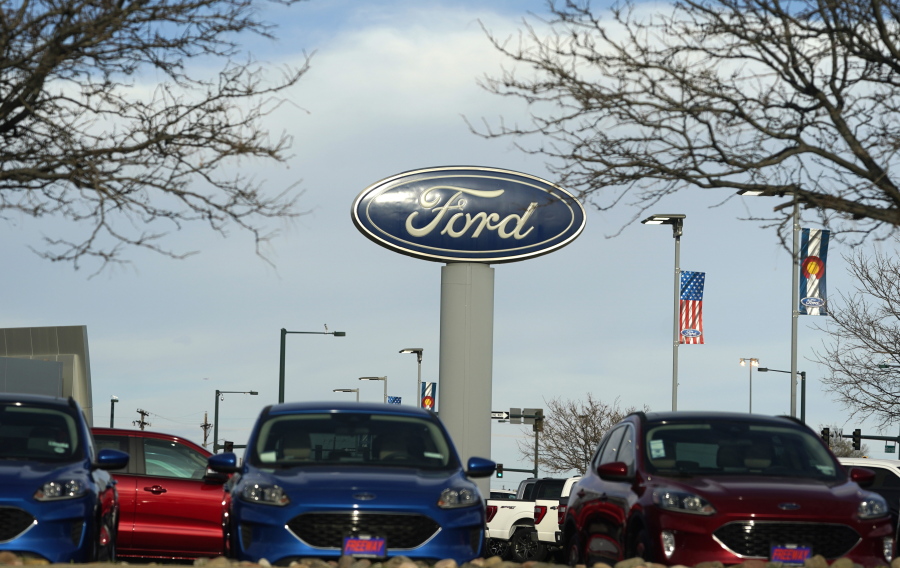 FILE - In this April 25, 2021 file photo, the blue oval logo of Ford Motor Company is displayed on a sign over a row of vehicles at a dealership in east Denver. Ford will add 6,200 factory jobs in Michigan, Missouri and Ohio as it prepares to build more electric vehicles and roll out two redesigned combustion-engine models, the company announced, Thursday, June 2, 2022.