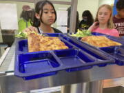 Students get lunch of homemade pizza and caesar salad at the Albert D. Lawton Intermediate School, in Essex Junction, Vt., Thursday, June 9, 2022. The pandemic-era federal aid that made school meals available for free to all public school students -- regardless of family income levels -- is ending, raising fears about the effects in the upcoming school year for families already struggling with rising food and fuel costs.