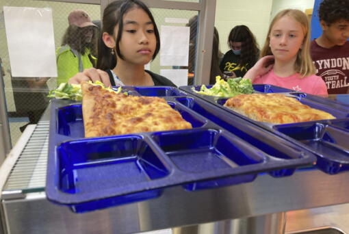 Students get lunch of homemade pizza and caesar salad at the Albert D. Lawton Intermediate School, in Essex Junction, Vt., Thursday, June 9, 2022. The pandemic-era federal aid that made school meals available for free to all public school students -- regardless of family income levels -- is ending, raising fears about the effects in the upcoming school year for families already struggling with rising food and fuel costs.