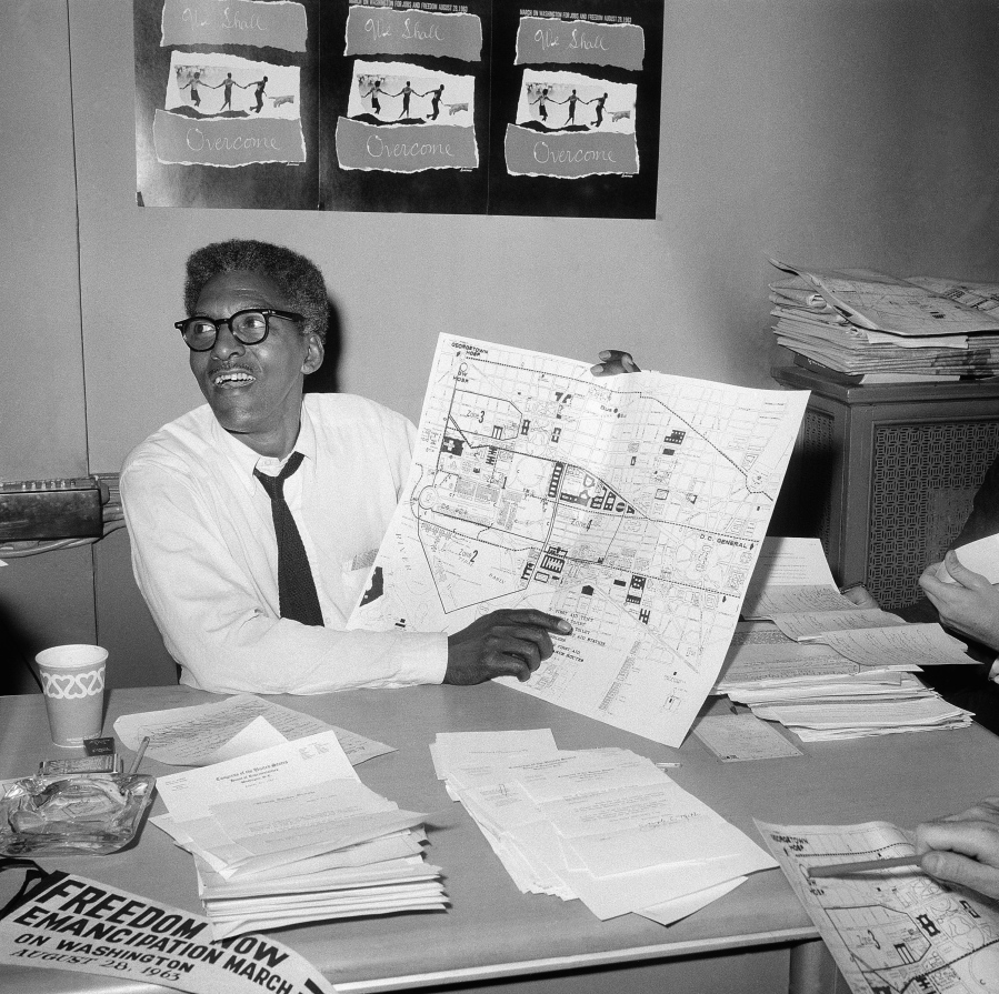 FILE - Bayard Rustin, deputy director of the planned march on Washington program, points to a map showing the line of march for the demonstration for civil rights during a news conference in New York on Aug. 24, 1963.