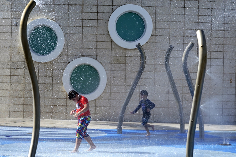 Children play at a water park, Monday, June 13, 2022, in Miami Beach, Fla. More than 100 million Americans are being warned to stay indoors if possible as high temperatures and humidity settle in over states stretching through parts of the Gulf Coast to the Great Lakes and east to the Carolinas.