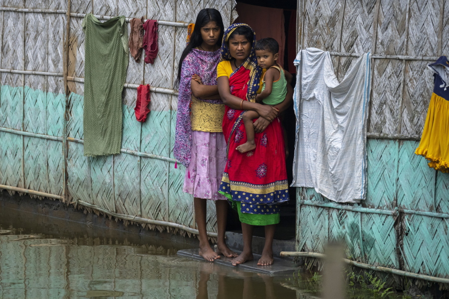 A flood affected family waits for the help at marooned Tarabari village, west of Gauhati, in the northeastern Indian state of Assam, Monday, June 20, 2022. Authorities in India and Bangladesh are struggling to deliver food and drinking water to hundreds of thousands of people evacuated from their homes in days of flooding that have submerged wide swaths of the countries. The floods triggered by monsoon rains have killed more than a dozen people, marooned millions and flooded millions of houses.