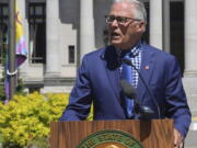 Washington state Gov. Jay Inslee addresses a gathering before raising the LGBTQ Pride Celebration flag seen behind him during a noon ceremony at the Capitol Campus flag circle, Tuesday, June 21, 2022, in Olympia, Wash. A variety of events celebrating the LGBTQ community statewide have taken place and are also scheduled through the month of June.
