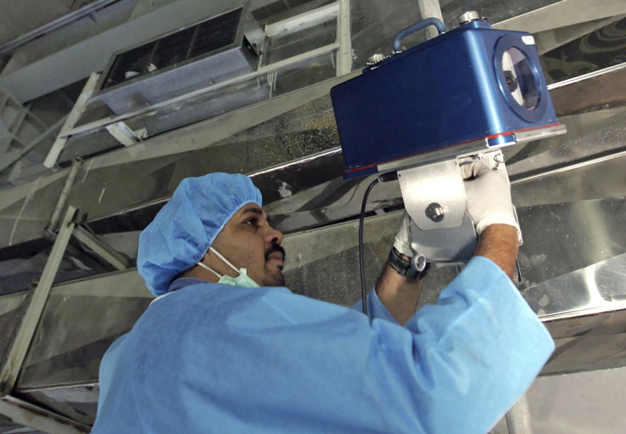 FILE - An inspector of the International Atomic Energy Agency sets up surveillance equipment, at the Uranium Conversion Facility of Iran, just outside the city of Isfahan, Iran, Aug. 8, 2005. Iran turned off two surveillance cameras of the United Nations' nuclear watchdog that monitored one of its atomic sites, state television reported Wednesday, June 8, 2022. The report did not identify the site.