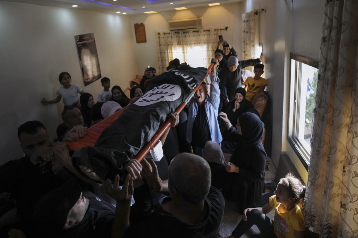 Mourners carry the body of Palestinian Bara Lahlouh, 24, at his family home, in the West Bank town of Jenin, Friday, June 17, 2022. Israeli forces shot dead Lahlouh and another two Palestinians and wounded eight others early Friday during a military operation in the occupied West Bank town of Jenin, the Palestinian Health Ministry said. The military said the troops traded fire with militants.