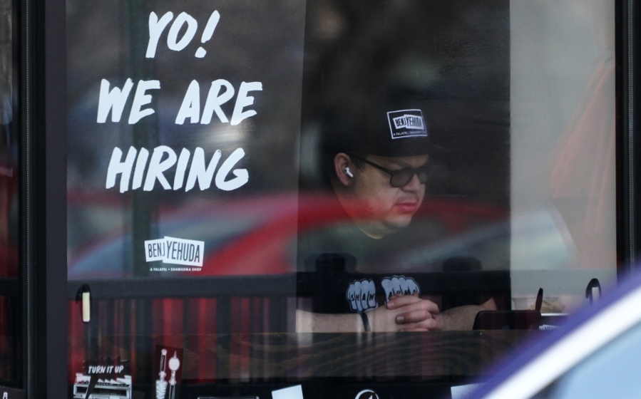 FILE - A hiring sign is displayed at a restaurant in Schaumburg, Ill., April 1, 2022. The white-hot demand for U.S. workers cooled a bit in April, though the number of unfilled jobs remains high and companies are still desperate to hire more people. Employers advertised 11.4 million jobs at the end of April, the Labor Department said Wednesday, June 1, 2022 down from nearly 11.9 million in March, the highest level on records that date back 20 years. (AP Photo/Nam Y.