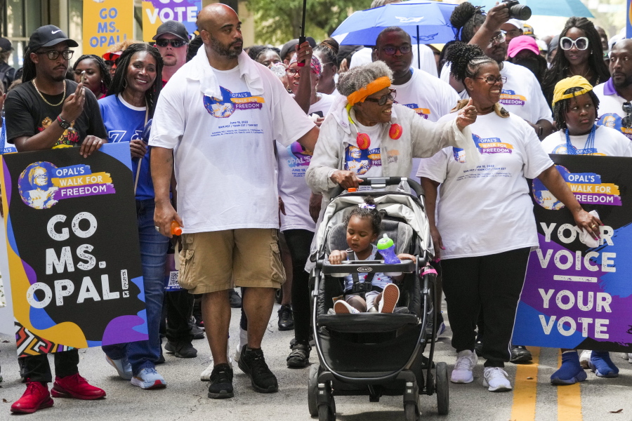 Opal Lee pushes one of her great granddaughters in a stroller as she waves to musicians playing along the route during the 2022 Opal's Walk for Freedom on Saturday, June 18, 2022, in Fort Worth. Lee, often referred to as the "Grandmother of Juneteenth" led her annual two-and-a-half-mile walk, representing the number of years after the Emancipation Proclamation before enslaved people in Texas learned they were free. (Smiley N.