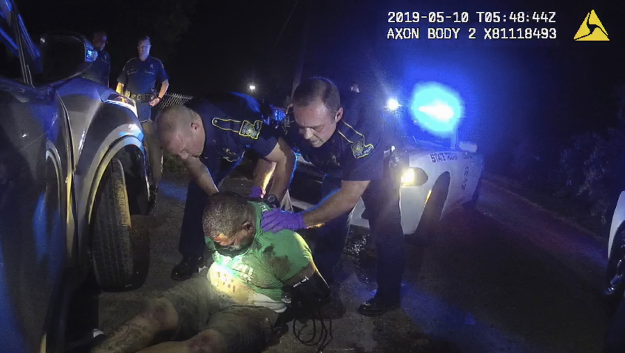 FILE - In this image from the body camera of Louisiana State Police Trooper Dakota DeMoss, his colleagues, Kory York, center left, and Chris Hollingsworth, center right, hold up Ronald Greene before paramedics arrived on May 10, 2019, outside of Monroe, La. No longer waiting for a federal investigation, state prosecutor Union Parish District Attorney John Belton says he intends to pursue his own case against the Louisiana troopers involved in the deadly 2019 arrest of Greene.