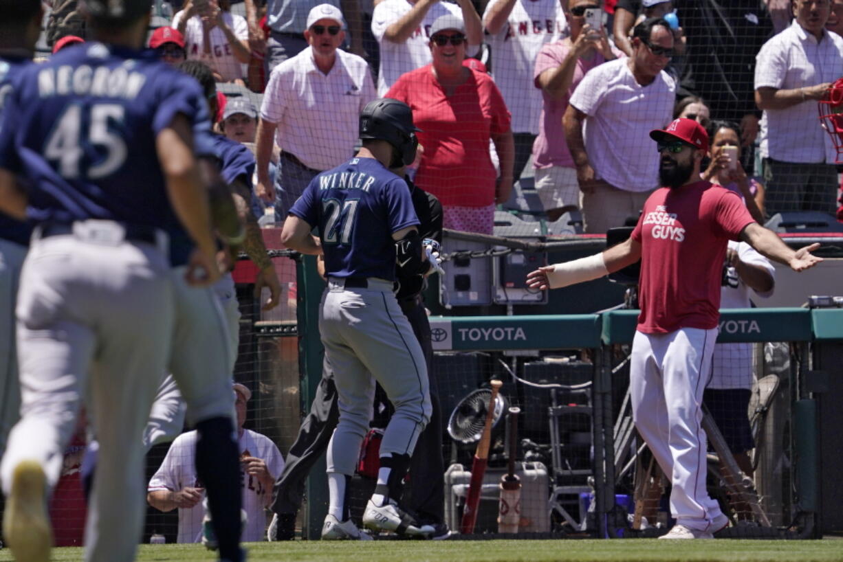 Seattle Mariners' Jesse Winker (27) gets set to fight with Los Angeles Angels Anthony Rendon after he was hit by a pitch and went after players in the Angels dugout during the second inning of a baseball game Sunday, June 26, 2022, in Anaheim, Calif. (AP Photo/Mark J.