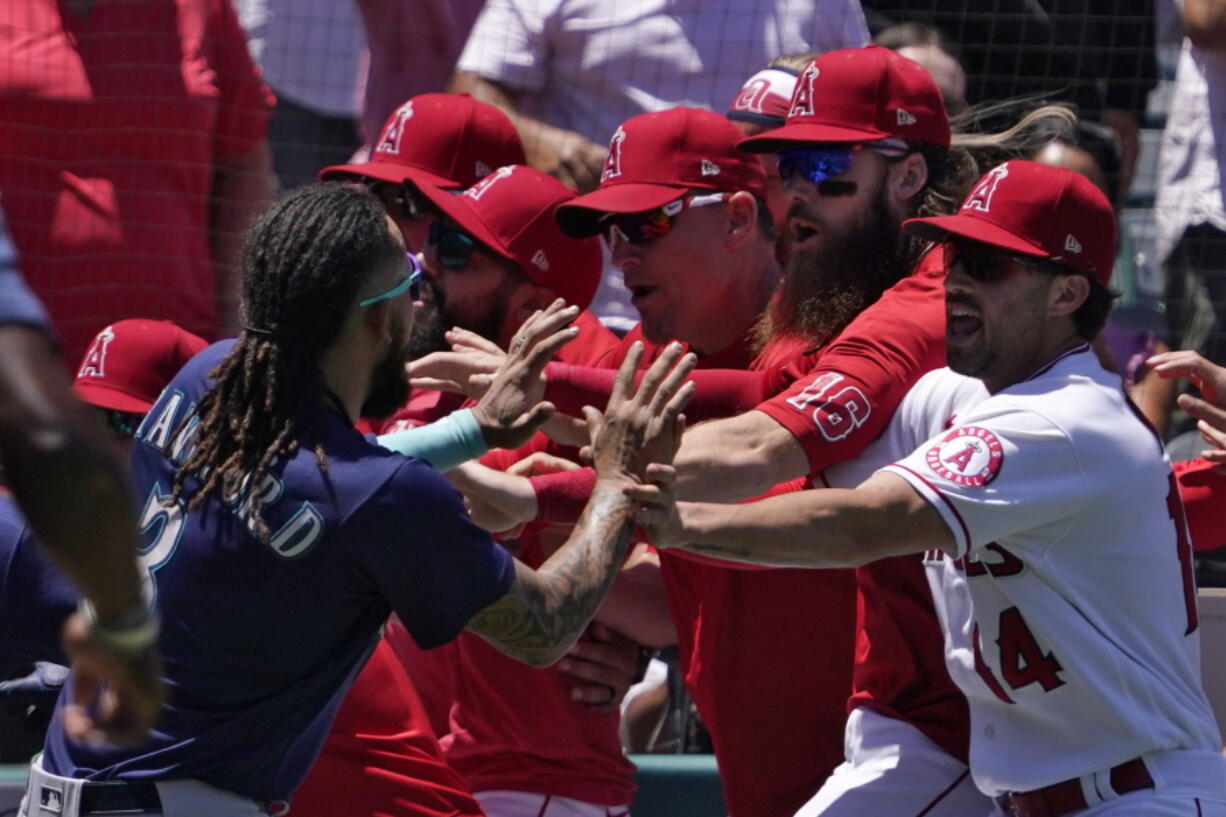 Seattle Mariners' J.P. Crawford, left, and several members of the Los Angeles Angels scuffle after Mariners' Jesse Winker was hit by a pitch during the second inning of a baseball game Sunday, June 26, 2022, in Anaheim, Calif. (AP Photo/Mark J. Terrill) (Mark J.