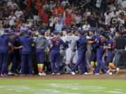 Both dugouts empty and umpires try to keep order after Seattle Mariners batter Ty France was hit by a pitch from Houston Astros relief pitcher Hector Neris during the ninth inning of a baseball game Monday, June 6, 2022, in Houston.