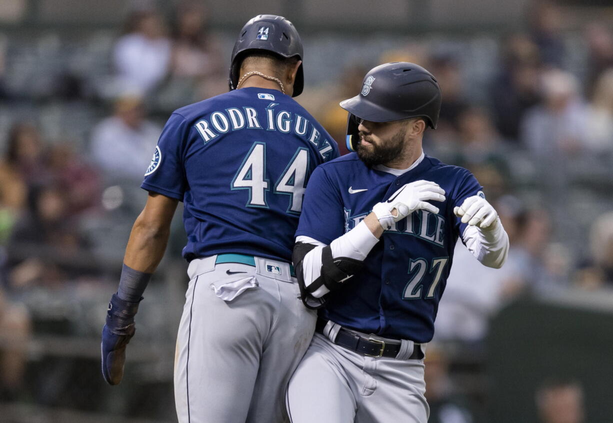 Seattle Mariners' Jesse Winker celebrates with Julio Rodriguez, left, after hitting a two-run home run against the Oakland Athletics during the fifth inning of a baseball game in Oakland, Calif., Wednesday, June 22, 2022.