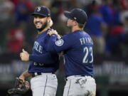 Seattle Mariners' Eugenio Suarez, left, and Ty France (23) celebrate their win in a baseball game against the Texas Rangers, Friday, June 3, 2022, in Arlington, Texas.