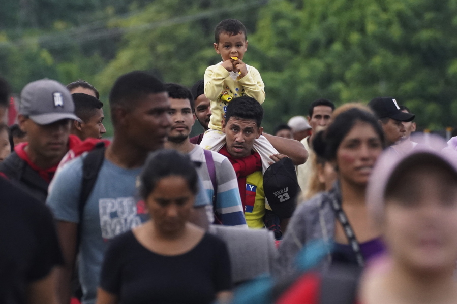 Migrants, many from Central American and Venezuela, walk along the Huehuetan highway in Chiapas state, Mexico, early Tuesday, June 7, 2022. The group left Tapachula on Monday, tired of waiting to normalize their status in a region with little work and still far from their ultimate goal of reaching the United States.