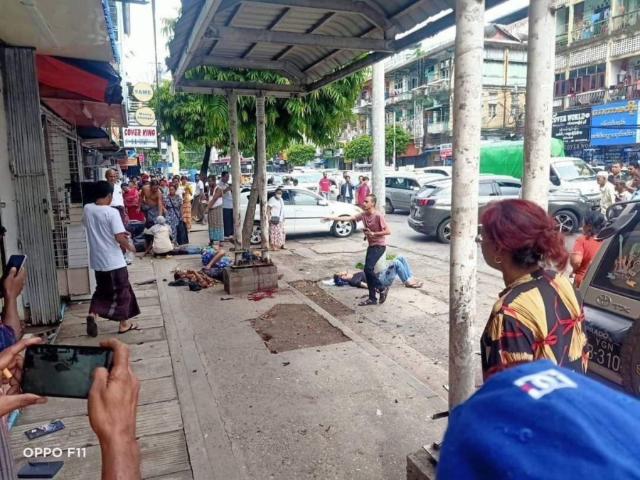 In this photo provided by the information office of Myanmar's military, four injured people can be seen lying on the pavement after an explosion at a bus stop in downtown Yangon on May 31, 2022. One person was killed and nine wounded when what authorities described as a handmade bomb exploded. The military and its foes blamed each other for the blast.