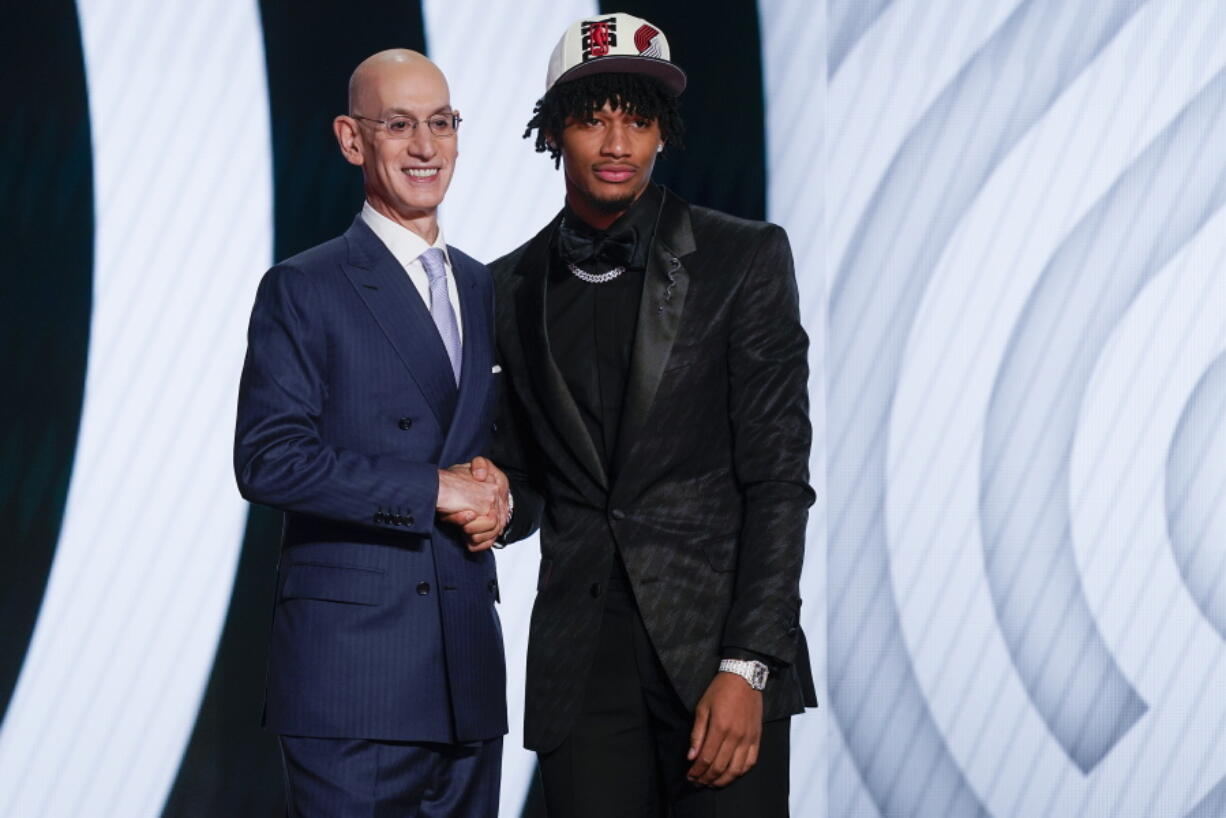 Shaedon Sharpe, right, shakes hands with NBA Commissioner Adam Silver after being selected seventh overall by the Portland Trailblazers in the NBA basketball draft, Thursday, June 23, 2022, in New York.