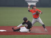 Auburn infielder Brody Moore, right, throws to first base after putting out Oregon State's Justin Boyd, left, during the first inning on Monday in Corvallis, Ore.