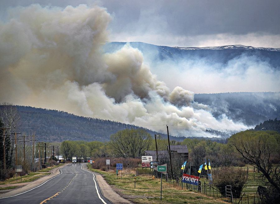 FILE - A flare up near Cleveland, just down 519 from Mora, N.M., darkens the sky on Wednesday, May 4, 2022, where firefighters have been battling the Hermit's Peak and Calf Canyon fire for weeks. New Mexico residents are suing the U.S. Forest Service for information on a massive wildfire that's been burning in the state since late April. The agency has been criticized for its role in causing two wildfires that merged to become the largest blaze in New Mexico history.