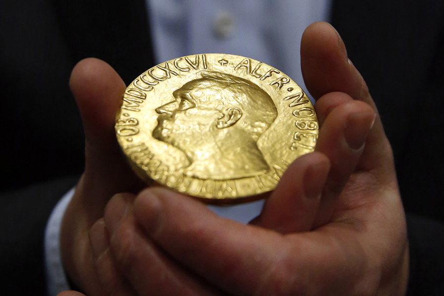 FILE -- Bidder Ole Bjorn Fausa, of Norway, holds the 1936 Nobel Peace Prize medal in Baltimore, March 27, 2014, the second Nobel Peace Prize ever to come to auction. The Nobel Peace Prize, won last October by Russian journalist Dmitri A. Muratov, will be offered at auction, Monday, June 20, 2022, with proceeds going to help children displaced by the war in Ukraine.
