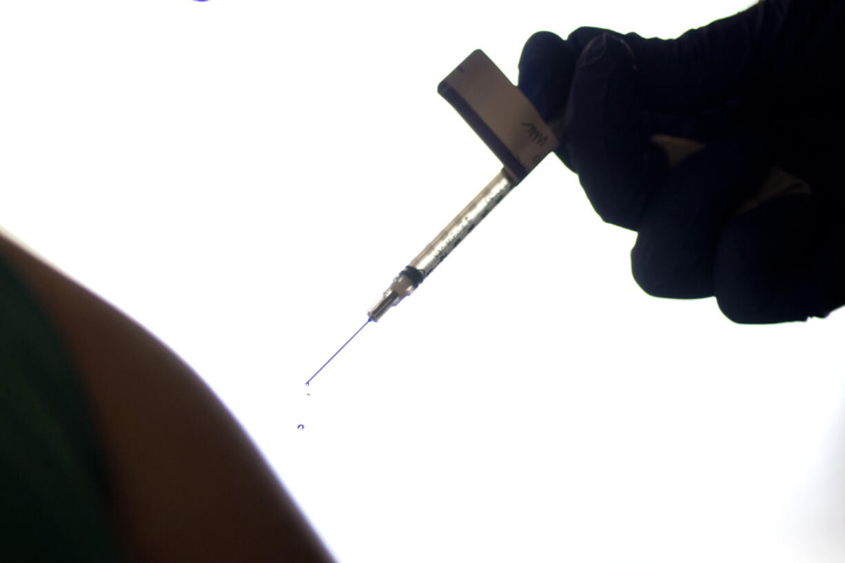 FILE - A droplet falls from a syringe after a health care worker was injected with the Pfizer-BioNTech COVID-19 vaccine at Women & Infants Hospital in Providence, R.I., on Dec. 15, 2020. On Friday, June 10, 2022, The Associated Press reported on stories circulating online incorrectly claiming that 20,000 people have died from COVID-19 vaccines. The figure misrepresents data maintained by the Centers for Disease Control and Prevention and the Food and Drug Administration. To date, a total of nine deaths in the U.S. have been linked to the shots.