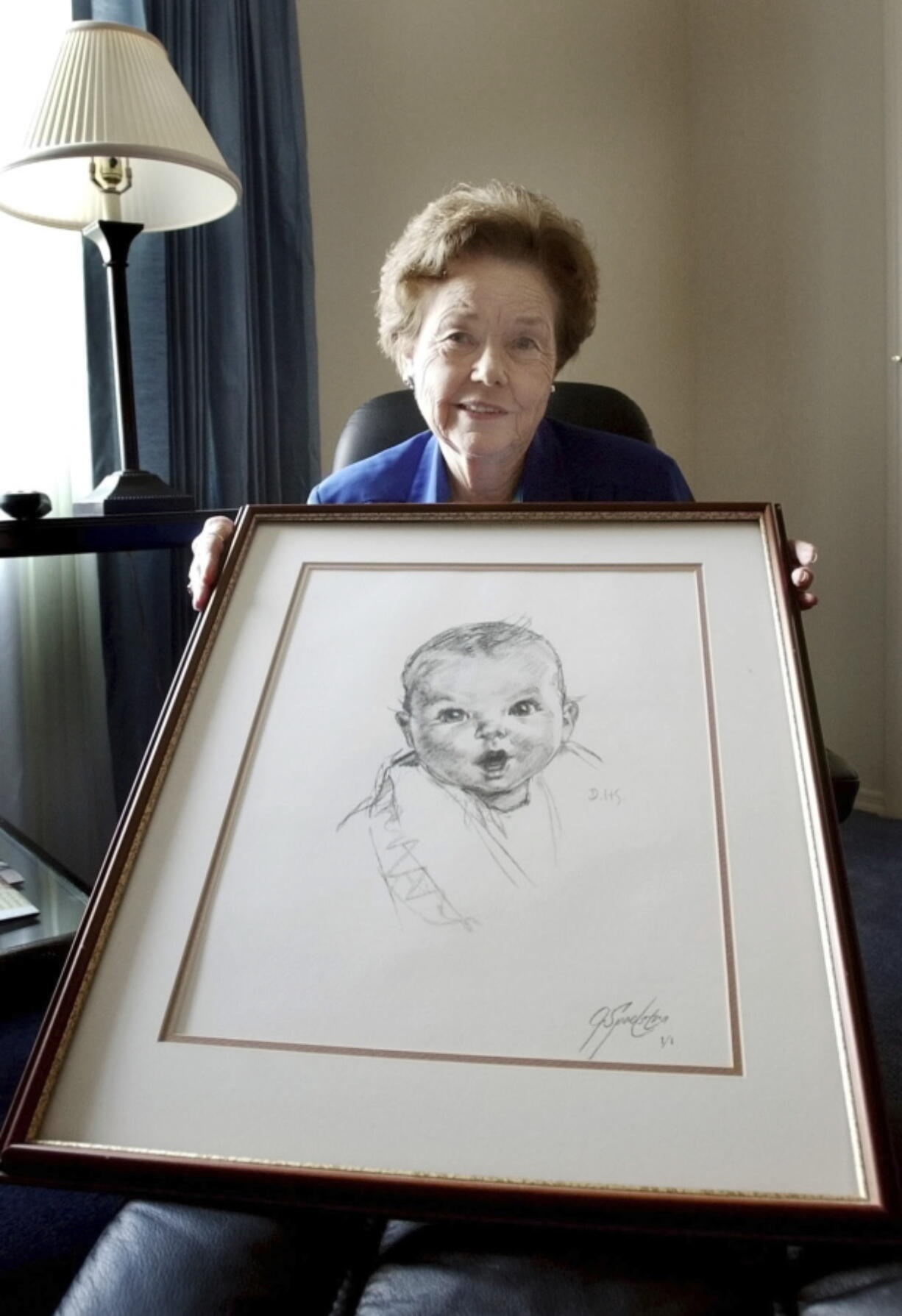 Ann Turner Cook holds a copy of her image that is used on all Gerber baby food products at her Tampa, Fla., home in 2004.