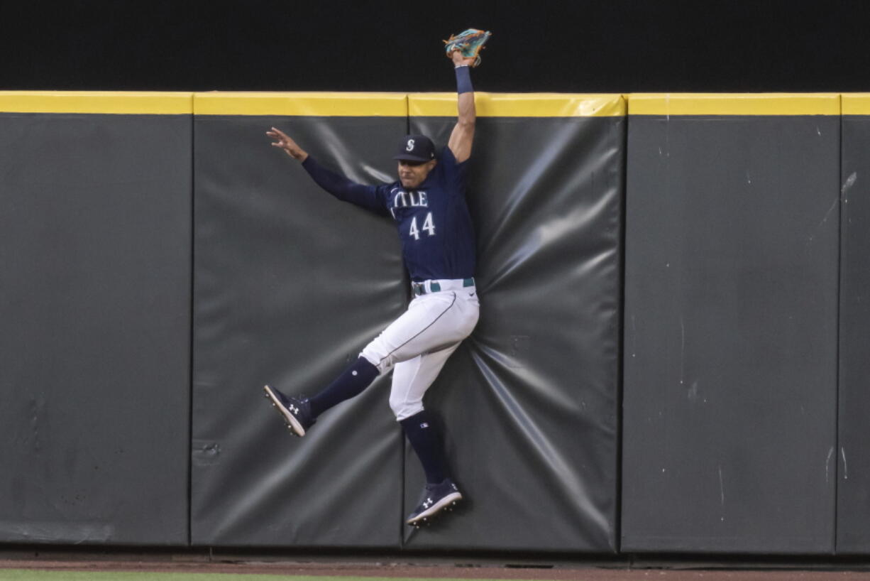 Seattle Mariners centerfielder Julio Rodriguez hits the outfield wall after failing to catch a home run ball hit by Baltimore Orioles' Jorge Mateo during the sixth inning of a baseball game, Monday, June 27, 2022, in Seattle.