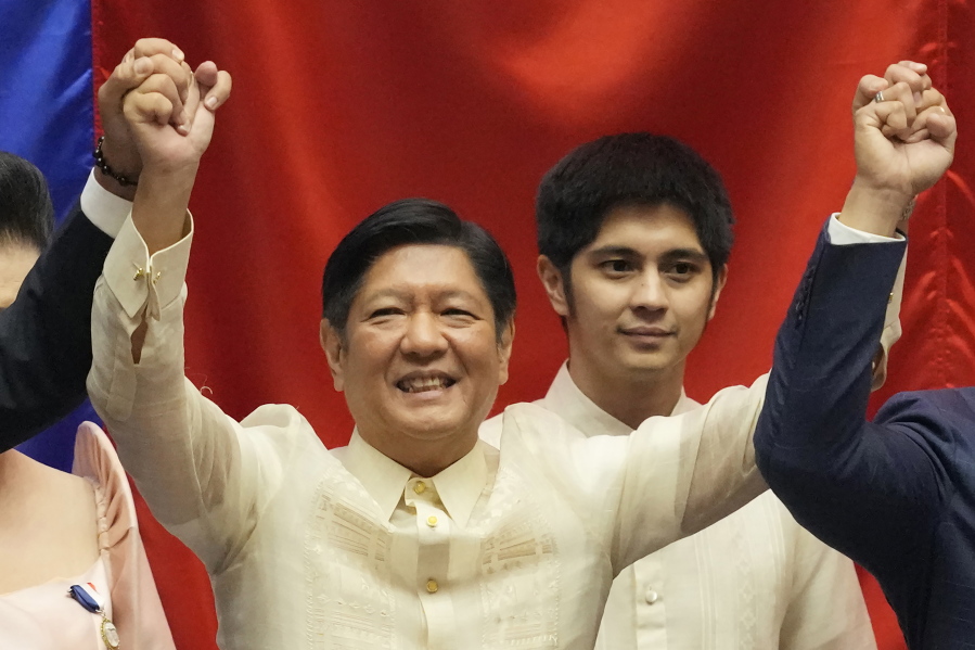 FILE - President-elect Ferdinand "Bongbong" Marcos Jr. raises hands with Senate President Vicente Sotto III, left, and House Speaker Lord Allan Velasco during his proclamation at the House of Representatives, Quezon City, Philippines on May 25, 2022. A top State Department official met Thursday, June 9, 2022 with Marcos in Manila, part of an ongoing diplomatic outreach in the Asia-Pacific region that Washington has undertaken to try and blunt growing Chinese influence.