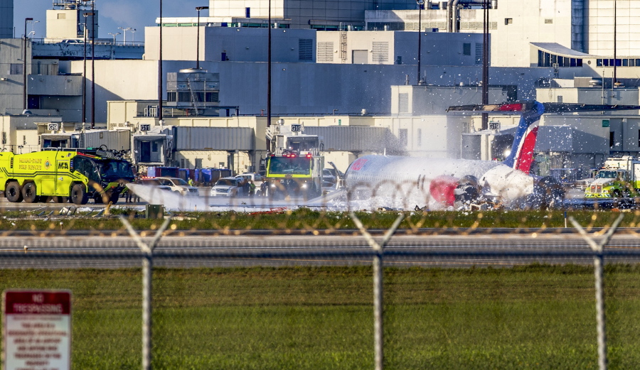 Firefighting units are seen next to a Red Air plane that caught fire after the front landing gear collapsed upon landing at Miami International Airport in Miami, after arriving from Santo Domingo, Dominican Republic, Tuesday, June 21, 2022.