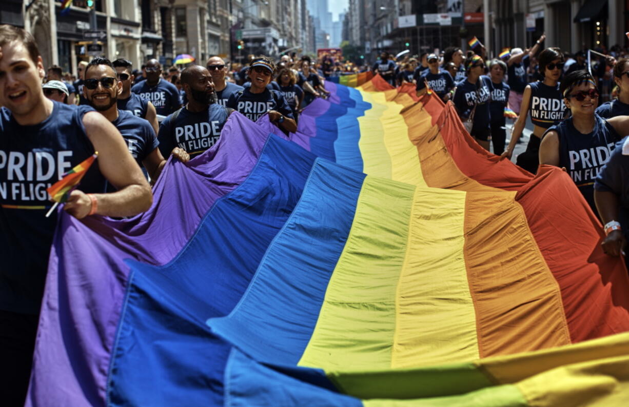FILE - Reveler carry a LTBGQ flag along Fifth Avenue during the New York City Pride Parade on Sunday, June 24, 2018, in New York. Parades celebrating LGBTQ pride kick off in some of America's biggest cities Sunday amid new fears about the potential erosion of freedoms won through decades of activism. The annual marches in New York, San Francisco, Chicago and elsewhere take place just two days after one conservative justice on the Supreme Court signaled, in a ruling on abortion, that the court should reconsider the right to same-sex marriage recognized in 2015.