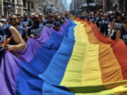FILE - Reveler carry a LTBGQ flag along Fifth Avenue during the New York City Pride Parade on Sunday, June 24, 2018, in New York. Parades celebrating LGBTQ pride kick off in some of America's biggest cities Sunday amid new fears about the potential erosion of freedoms won through decades of activism. The annual marches in New York, San Francisco, Chicago and elsewhere take place just two days after one conservative justice on the Supreme Court signaled, in a ruling on abortion, that the court should reconsider the right to same-sex marriage recognized in 2015.