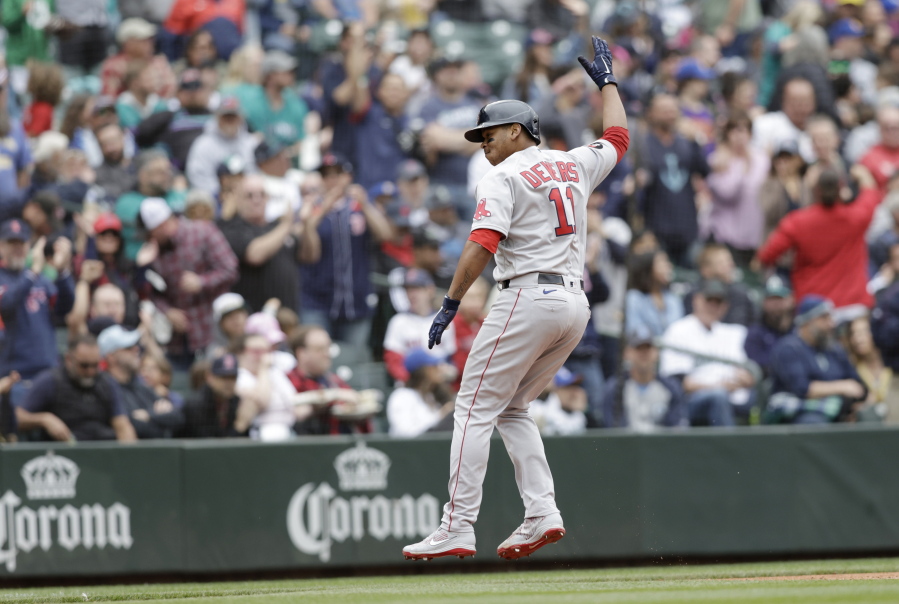 Boston Red Sox's Rafael Devers celebrates as he runs home after hitting a two-run home run on a pitch from Seattle Mariners' Paul Sewald during the eighth inning of a baseball game, Sunday, June 12, 2022, in Seattle.