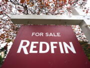 FILE - A Redfin "for sale" sign stands in front of a house on Oct. 28, 2020, in Seattle. The Seattle-based real estate brokerage says it will lay off 8% of its employees as the housing market cools off, Tuesday, June 14, 2022.