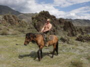 FILE - Then Russian Prime Minister Vladimir Putin rides a horse while traveling in the mountains of the Siberian Tyva region (also referred to as Tuva), Russia, Aug. 3, 2009. Putin has shot back at Western leaders who mocked his athletic exploits, saying they would look "disgusting" if they tried to emulate his bare-torso appearances. Putin made the comment during a visit to Turkmenistan early Thursday, June 30, 2022 when asked about Western leaders joking about him at the G-7 summit.