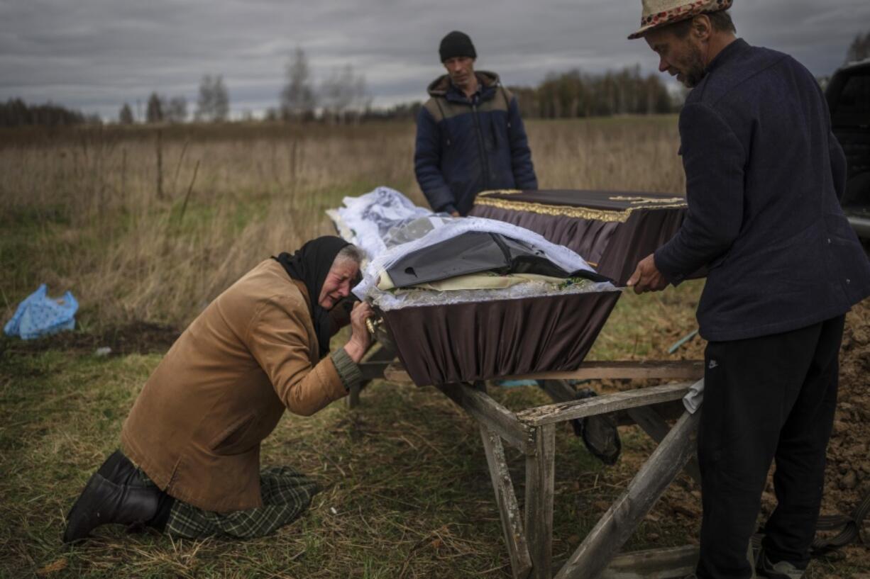 FILE - Nadiya Trubchaninova cries over the coffin of her son, Vadym, who was killed on March 30 by Russian soldiers in Bucha, Ukraine, during his funeral in the cemetery of nearby Mykulychi, on the outskirts of Kyiv, on April 16, 2022. Nobody knows how many civilians have died in the 100 days since Russia's invasion of Ukraine, but one thing is certain: the toll reaches into the tens of thousands.