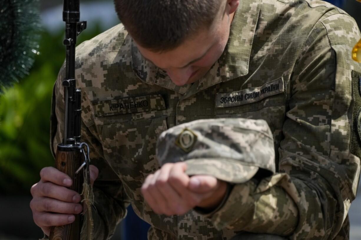 An Ukrainian serviceman mourns during the a funeral of Army Col. Oleksander Makhachek in Zhytomyr, Ukraine, Friday, June 3, 2022. According to combat comrades Makhachek was killed fighting Russian forces when a shell landed in his position on May 30.