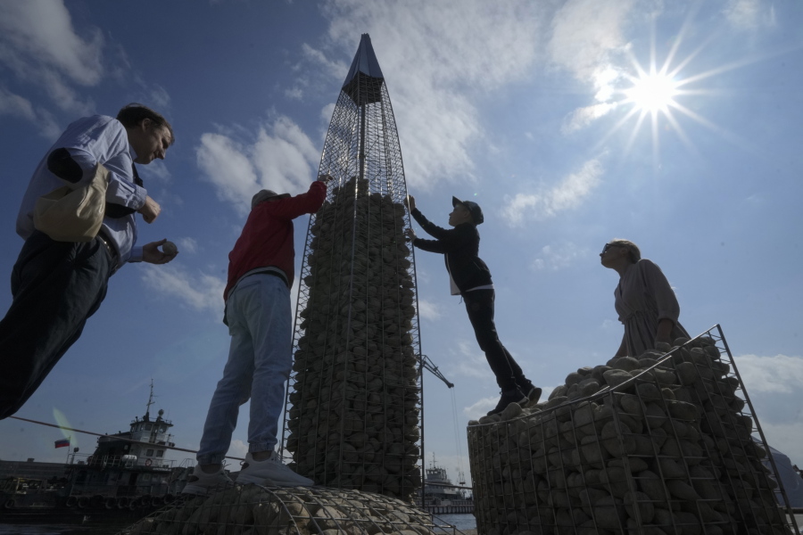 FILE - People build a model of the business tower Lakhta Centre, at the headquarters of Russian gas monopoly Gazprom, filling the frame with stones, in St. Petersburg, Russia, Thursday, June 9, 2022. It's not a summer heat wave that's making European leaders and businesses sweat. It's fear that Russia's manipulation of natural gas supplies will lead to an economic and political crisis next winter. Or, in the worst case, even sooner.