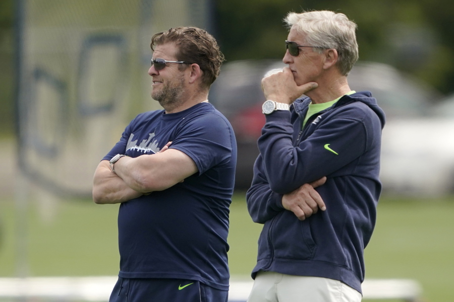Seattle Seahawks general manager John Schneider, left, and coach Pete Carroll watch NFL football practice Wednesday, June 8, 2022, in Renton, Wash. (AP Photo/Ted S.