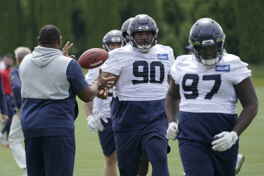 Seattle Seahawks defensive tackles Bryan Mone (90) and Poona Ford (97) run a drill during NFL football practice Wednesday, June 8, 2022, in Renton, Wash. (AP Photo/Ted S.