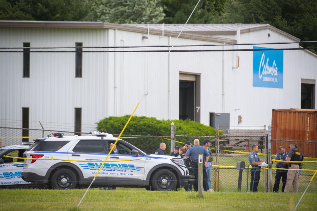Law enforcement officials stand near the scene of a shooting Thursday at Columbia Machine Inc., in Smithsburg, Md.