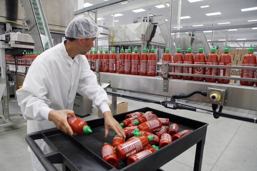 FILE - In this Oct 29, 2013 photo, Sriracha chili sauce is produced at the Huy Fong Foods factory in Irwindale, Calif. Bottles of the popular Sriracha hot sauce could be hard to find on store shelves this summer. Southern California-based Huy Fong Inc., told customers in an email earlier this year that it would suspend sales of its famous spicy sauce over the summer due to a shortage of chili peppers.