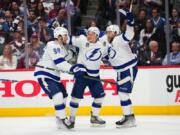 Tampa Bay Lightning left wing Ondrej Palat (18) celebrates a goal against the Colorado Avalanche with Mikhail Sergachev (98) and Steven Stamkos (91) during the third period in Game 5 of the NHL hockey Stanley Cup Final, Friday, June 24, 2022, in Denver.